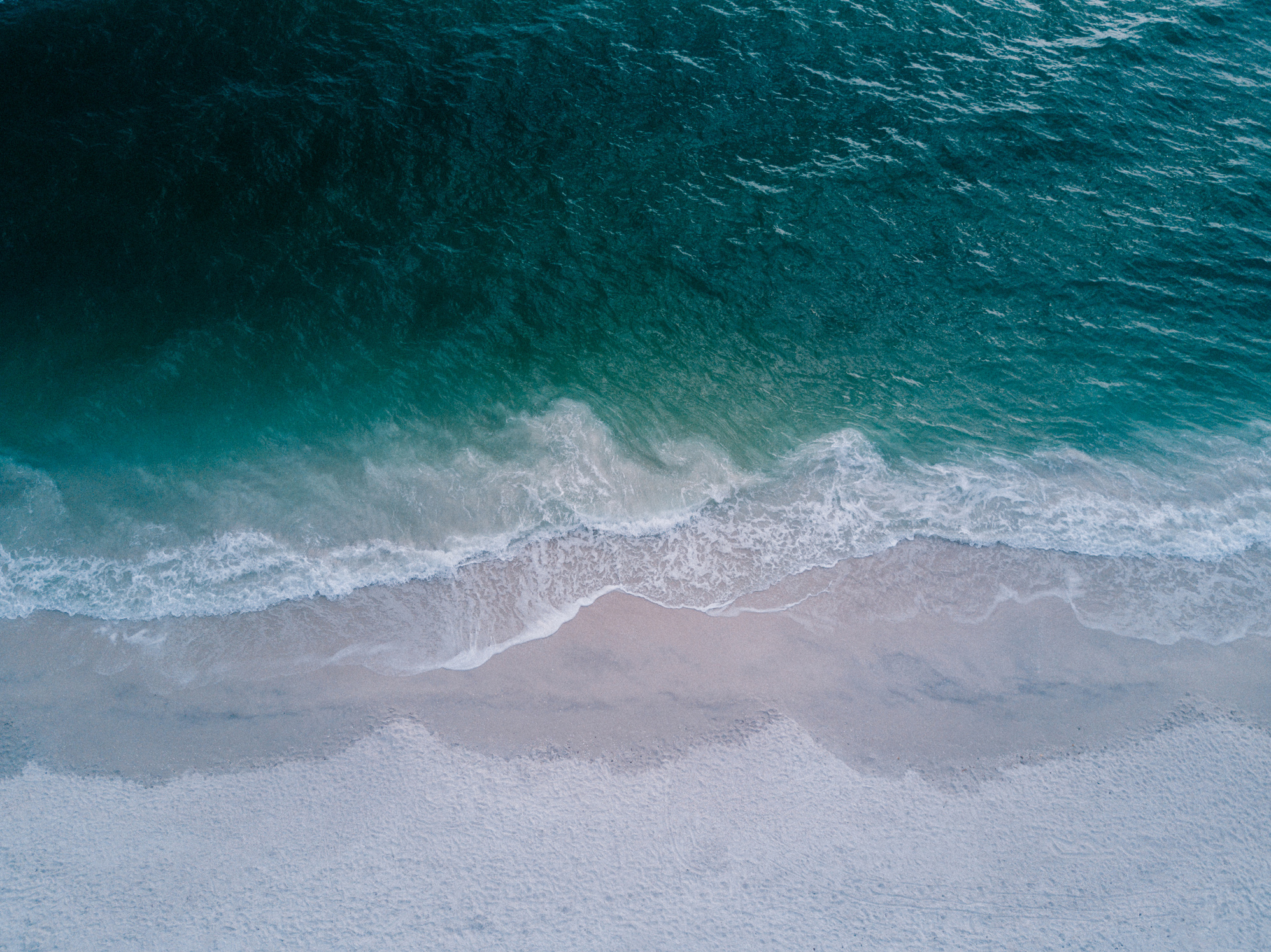 Body of Water Beside Beach Sand